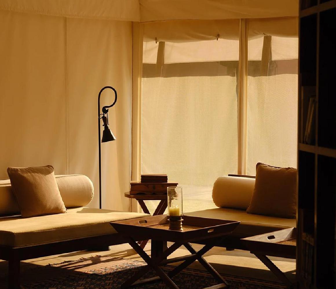 Luxe zithoek met daybedden in een canvas tentsuite