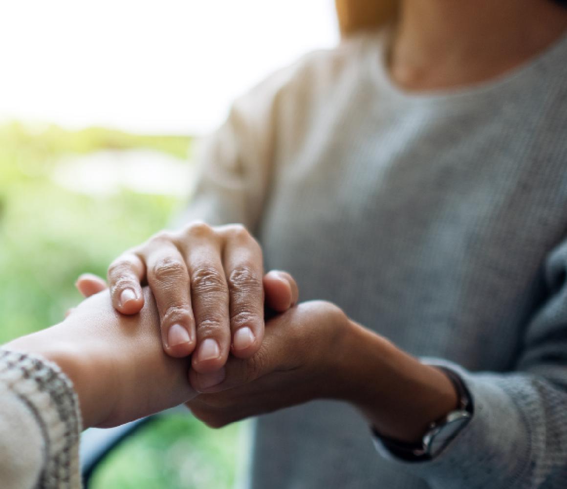 Twee mensen die elkaars hand vasthouden als steun