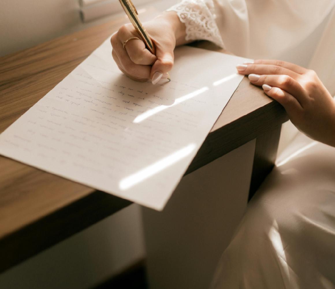Vrouw schrijft met de hand een brief aan een bureau