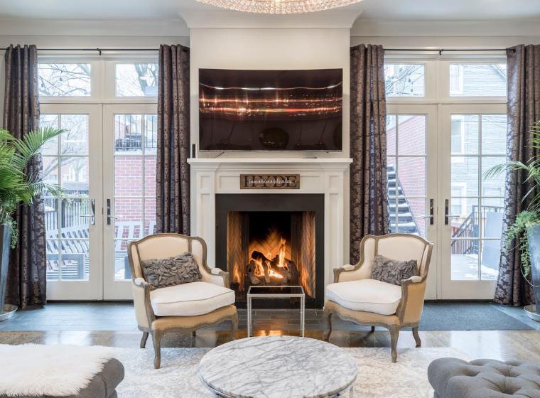 Woonkamer met brandende open haard en twee crème fauteuils