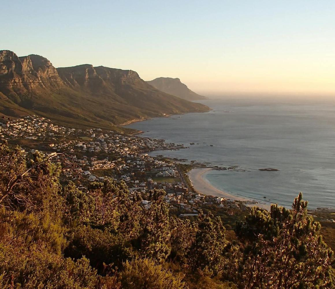 Uitzicht over een kustplaats aan de voet van bergen in Zuid-Afrika