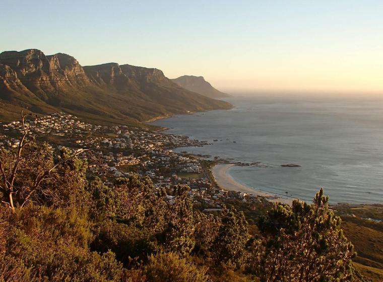 Uitzicht over een kustplaats aan de voet van bergen in Zuid-Afrika