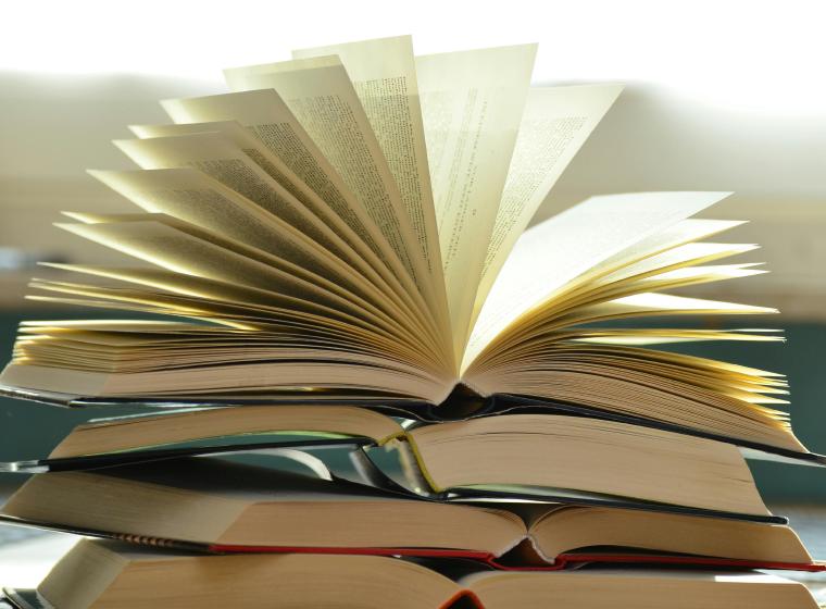Gestapelde open boeken met uitgewaaierde pagina's
