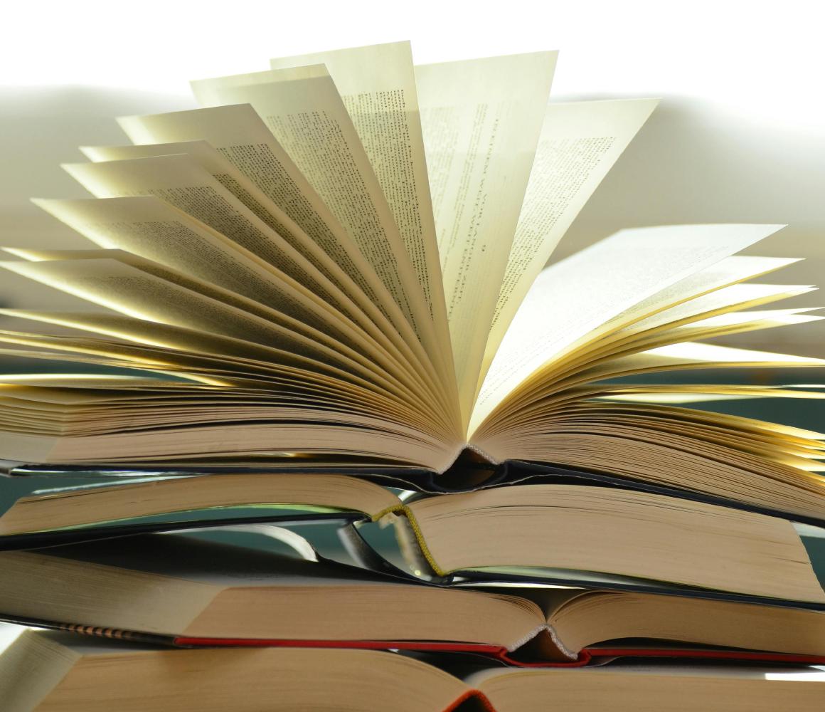 Gestapelde open boeken met uitgewaaierde pagina's