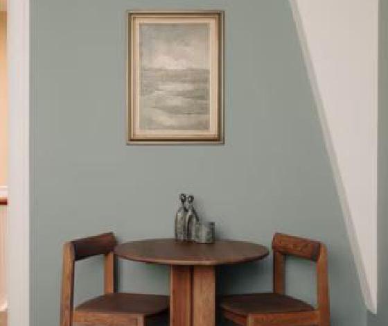 Eethoek met houten tafel en stillevenschilderij in de privé afkickkliniek van THE YOUTURN in Den Haag