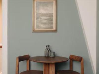 Eethoek met houten tafel en stillevenschilderij in de privé afkickkliniek van THE YOUTURN in Den Haag