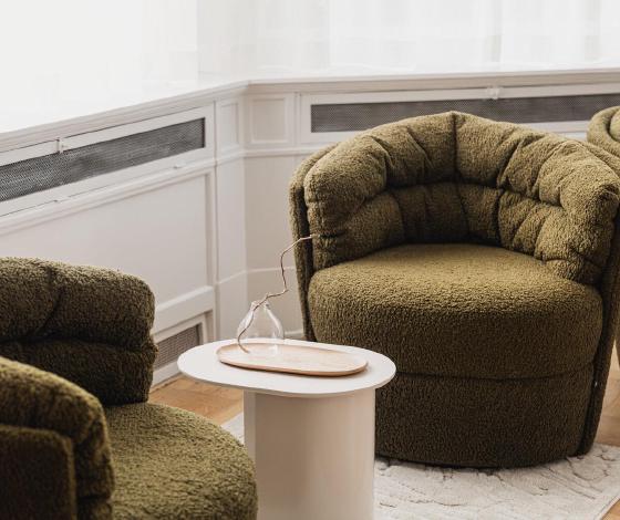 Twee groene fauteuils bij het raam in de privé afkickkliniek van THE YOUTURN in Haarlem