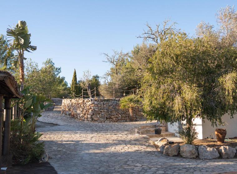 Tuinpad met natuurstenen muur en mediterrane beplanting bij Ibiza Calm