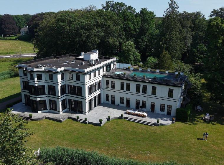 Luchtfoto van het pand van THE YOUTURN omgeven door bos en groene weiden