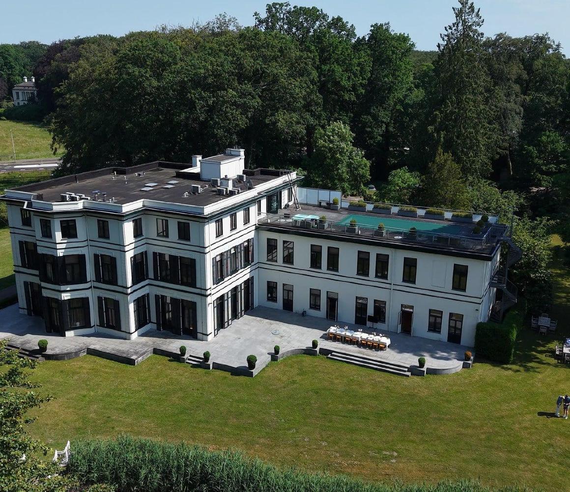 Luchtfoto van het pand van THE YOUTURN omgeven door bos en groene weiden